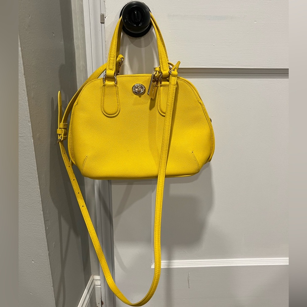 Coach yellow crossbody purse with gold accents and detachable strap